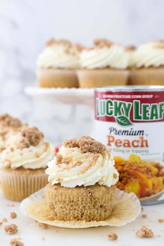 An unwrapped cupcake frosted and garnish with crumble, and a can of Luck Leaf pie filling in the background