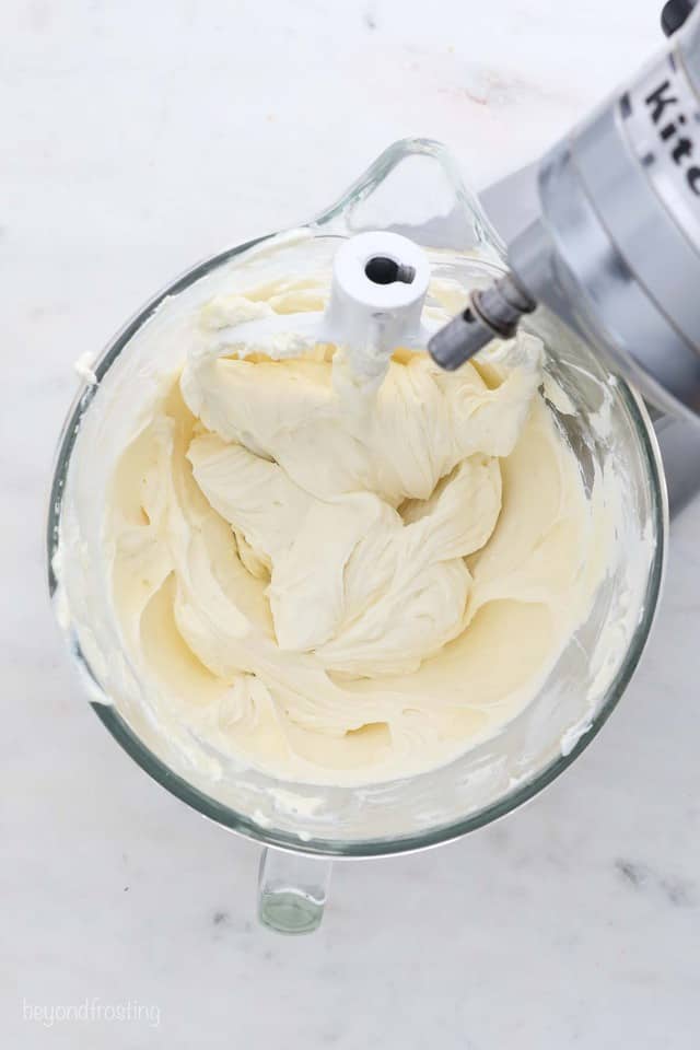 Cheese cake filling in a measuring cup with a hand mixer