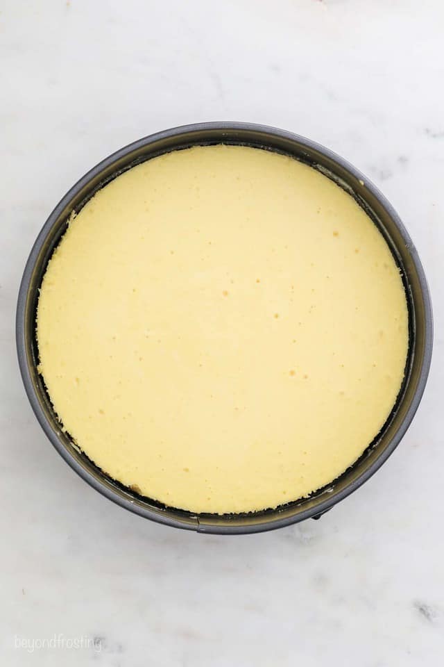 Creamy cheesecake batter in a springform pan ready to be baked.