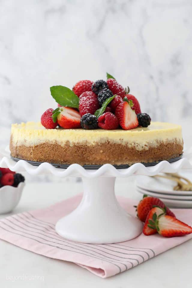 A creamy homemade cheesecake with graham cracker crust, topped with fresh strawberries and blackberries