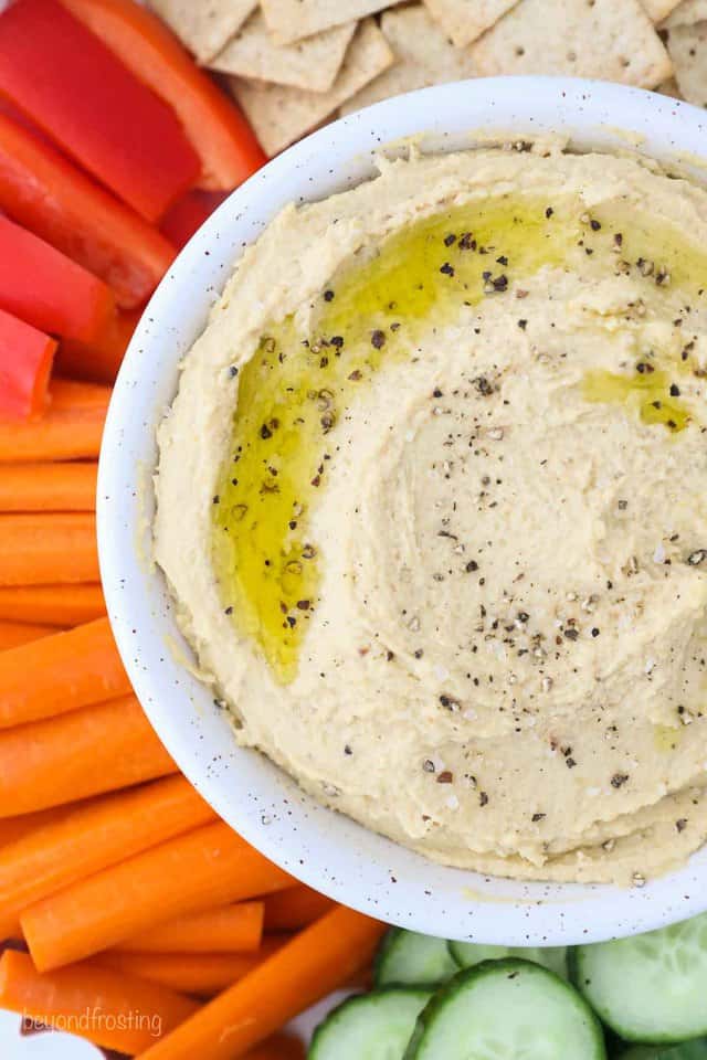 A Bowl of Hummus with Veggies and Chips Around its Perimeter