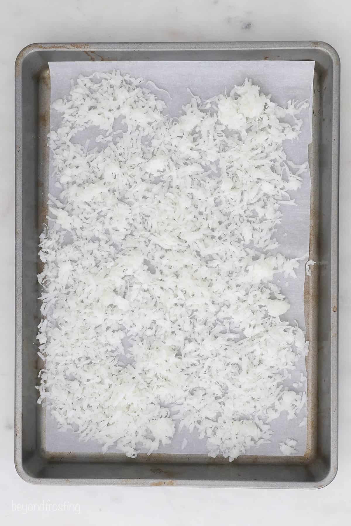 Coconut flakes spread on a baking sheet