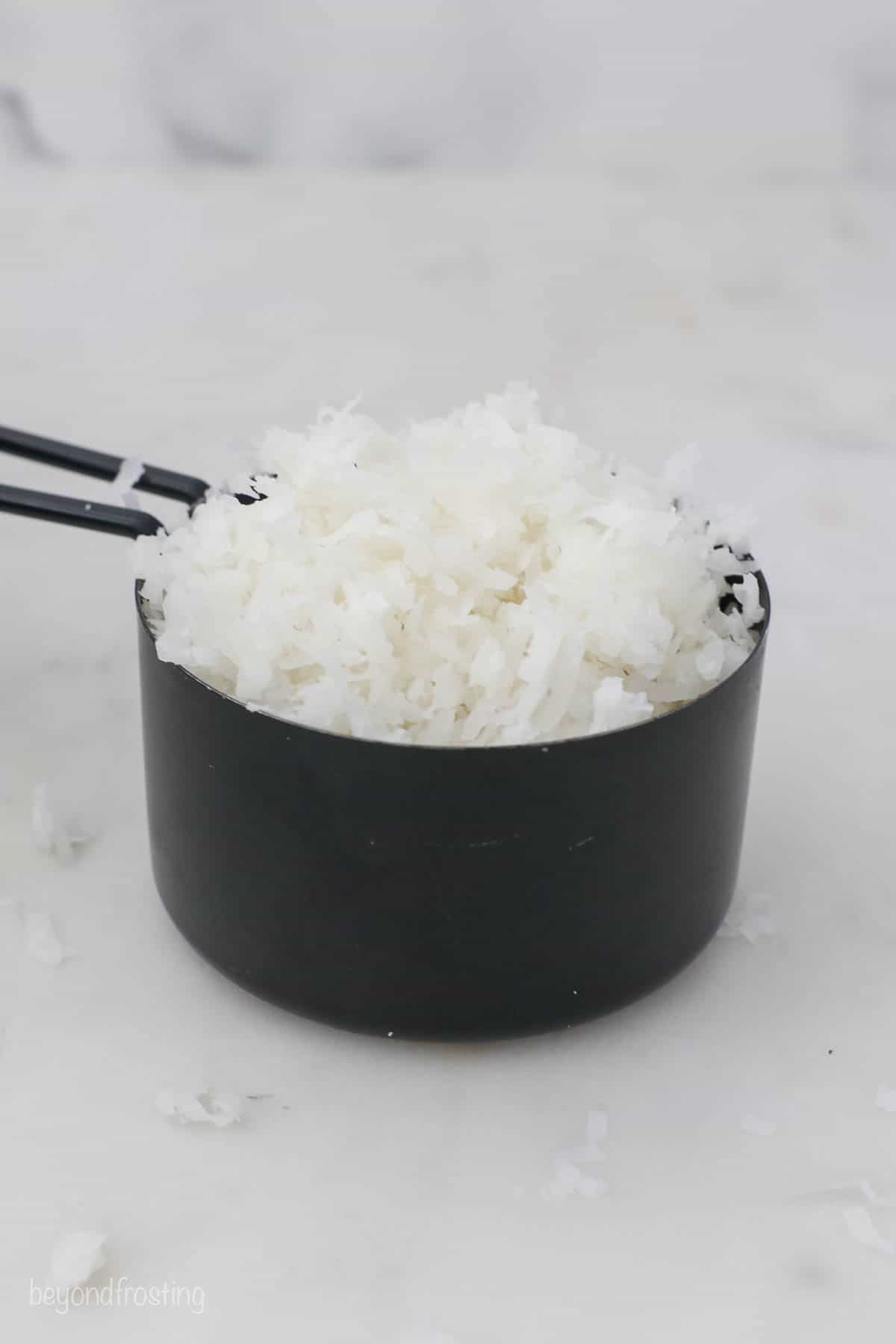 A meauring cup of coconut flakes