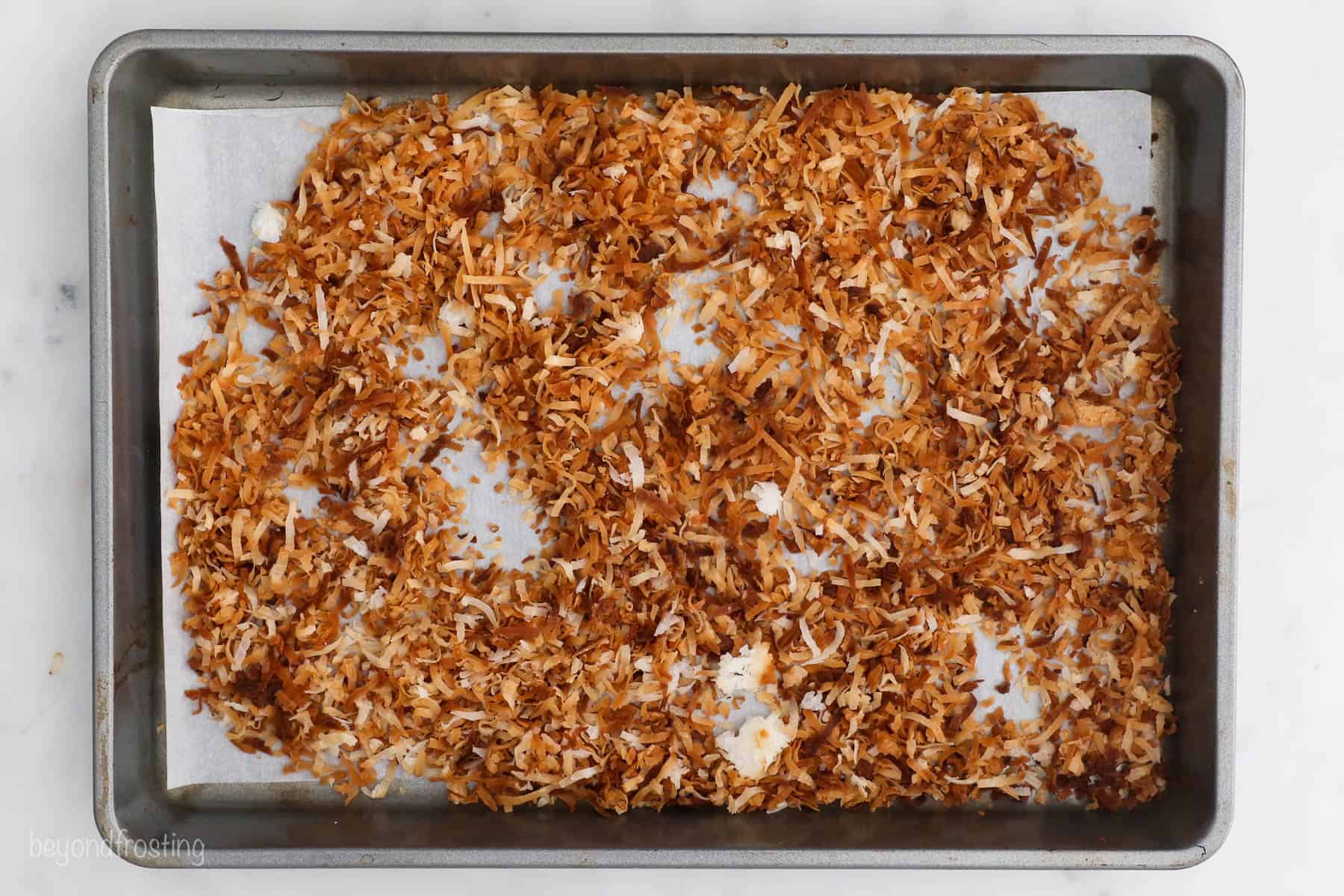 Toasted coconut spread on a baking sheet