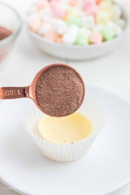 hot chocolate powder in a gold tablespoon measuring spoon