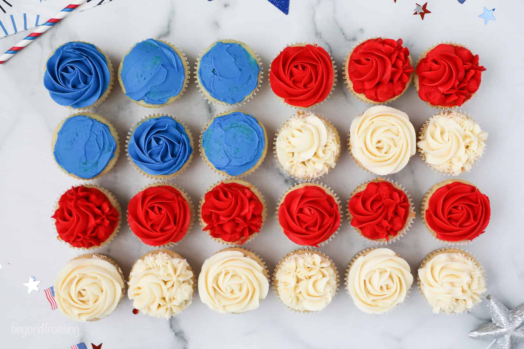 Overhead view of 24 cupcakes frosted red, white, and blue arranged in the shape of an American flag.