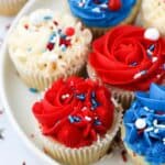 close up of red, white and blue frosted cupcakes on a white plate
