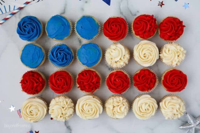 Birds eye view 24 cupcakes frosted in red white and blue laid out like a flag
