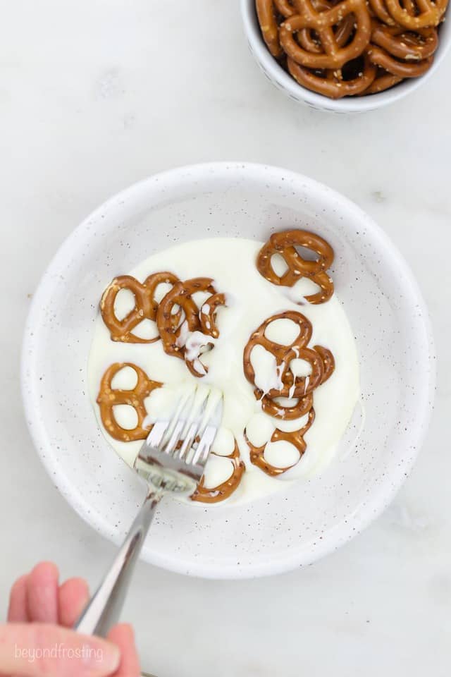 Mini pretzel twists in a bowl of melted white chocolate