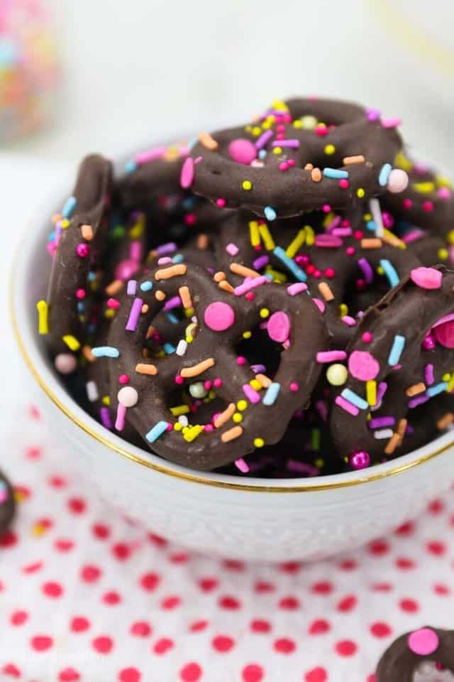 Mini pretzel twists covered in chocolate with blue pink and yellow sprinkles