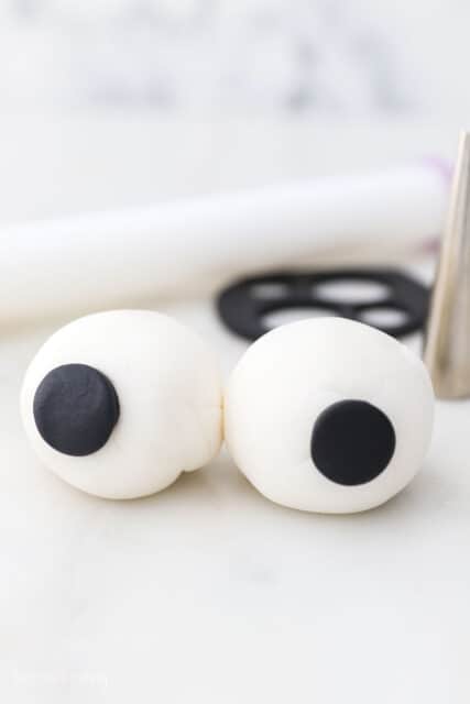 two fondant eyeballs on a marble surface