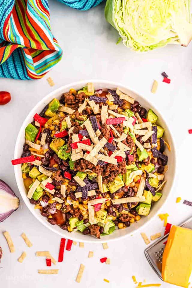 Aerial view of a big bowl of taco salad with ground beef, topped with cheese and tortilla strips