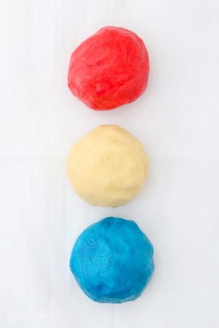 three large balls of cookie dough, stacked in red, white and blue colors