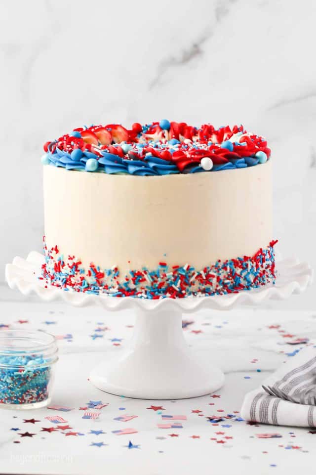a white cake plate with frosted and decorated with red white and blue sprinkles