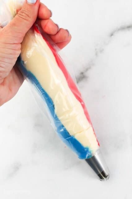 A piping bag filled with red, white and blue frosting