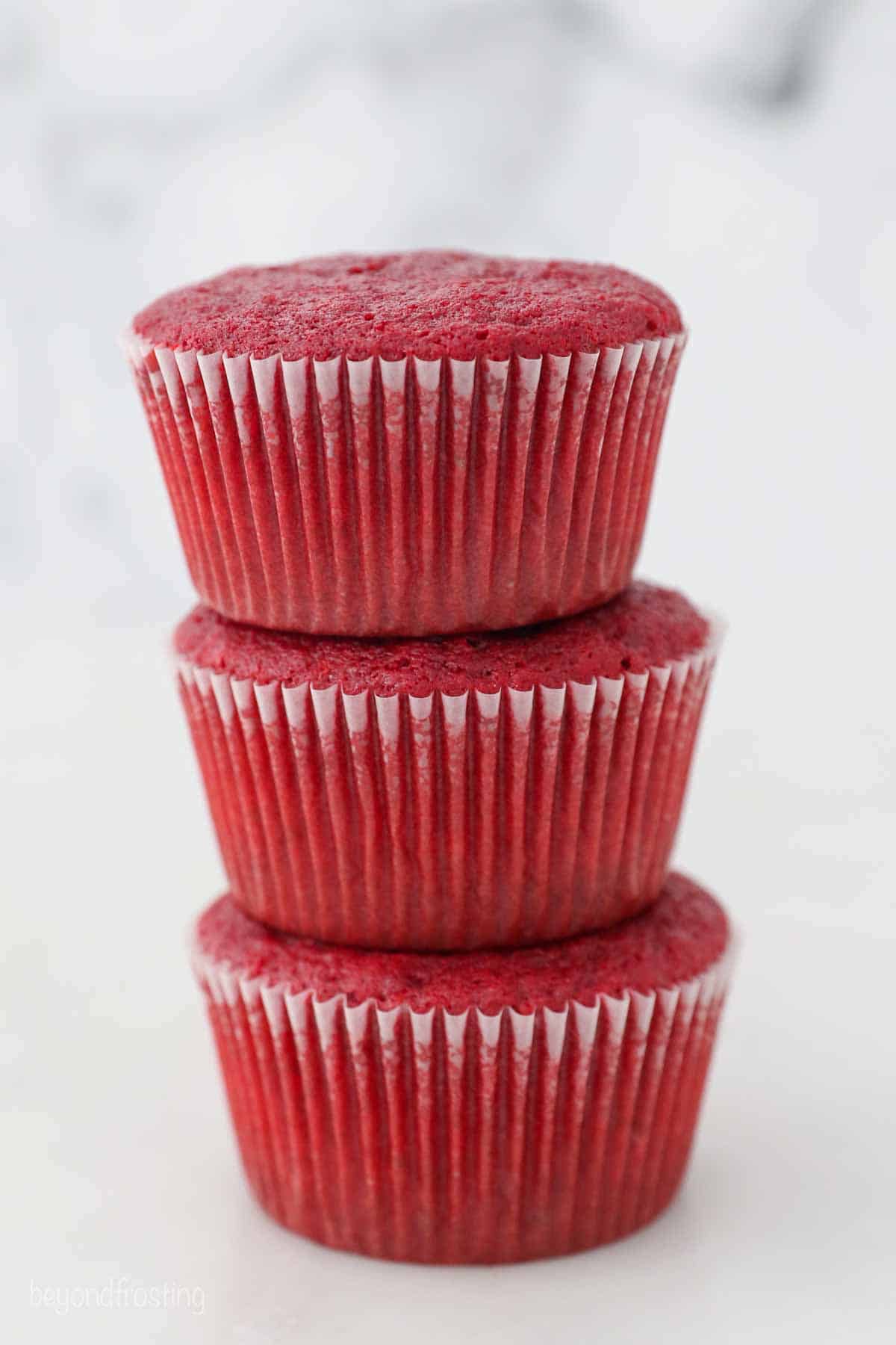 three stacked red velvet cupcakes without frosting
