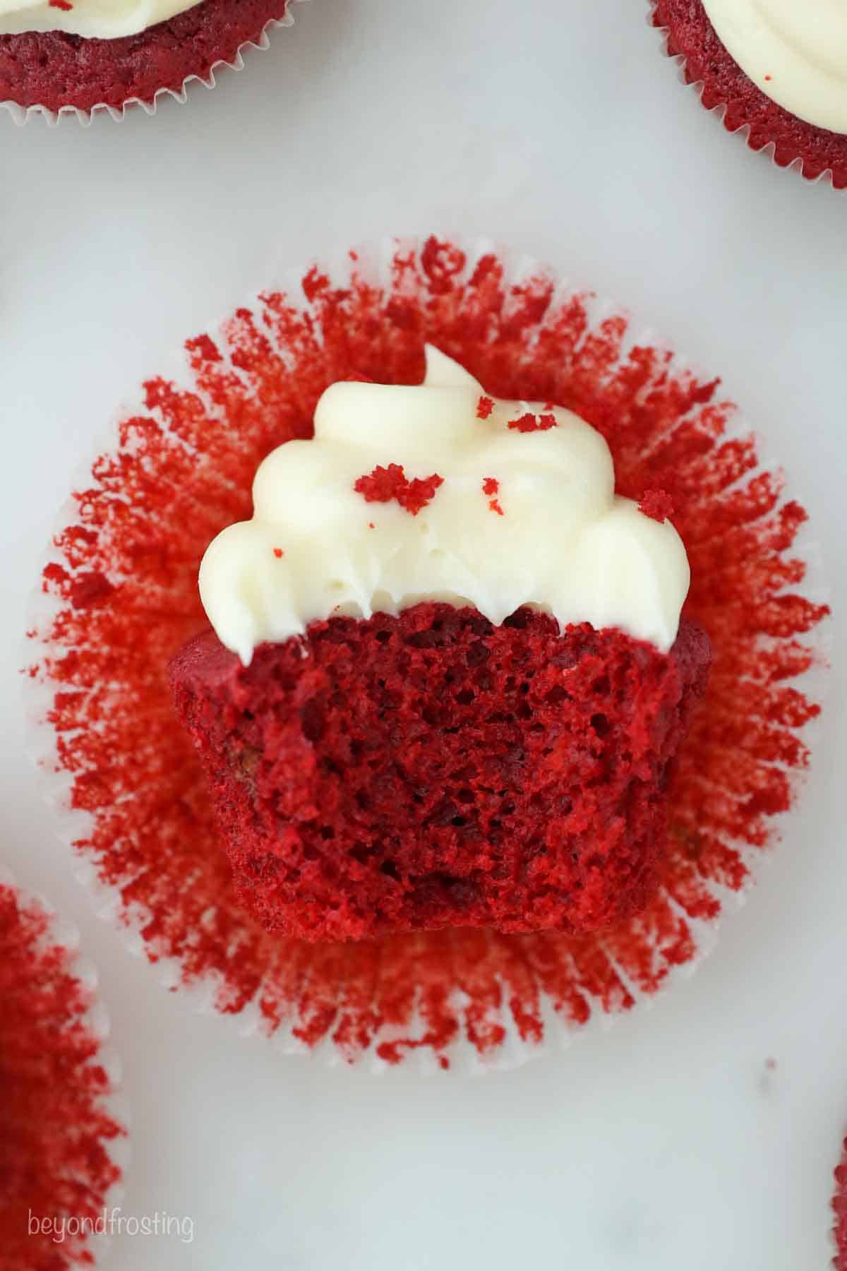 overhead shot of a frosted red velvet cupcake with a bite taken out of it