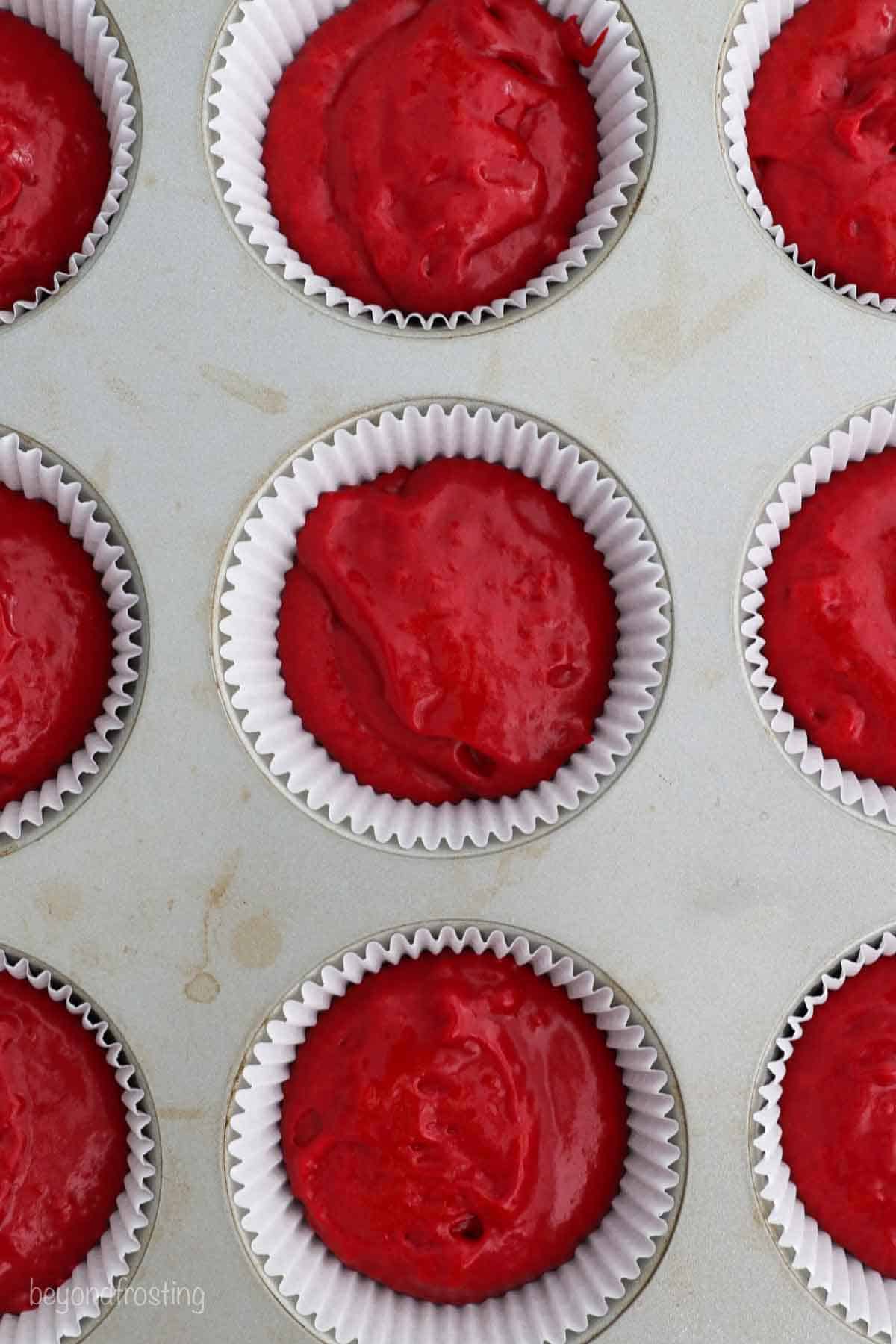 overhead of a cupcake pan filled with red velvet cake batter