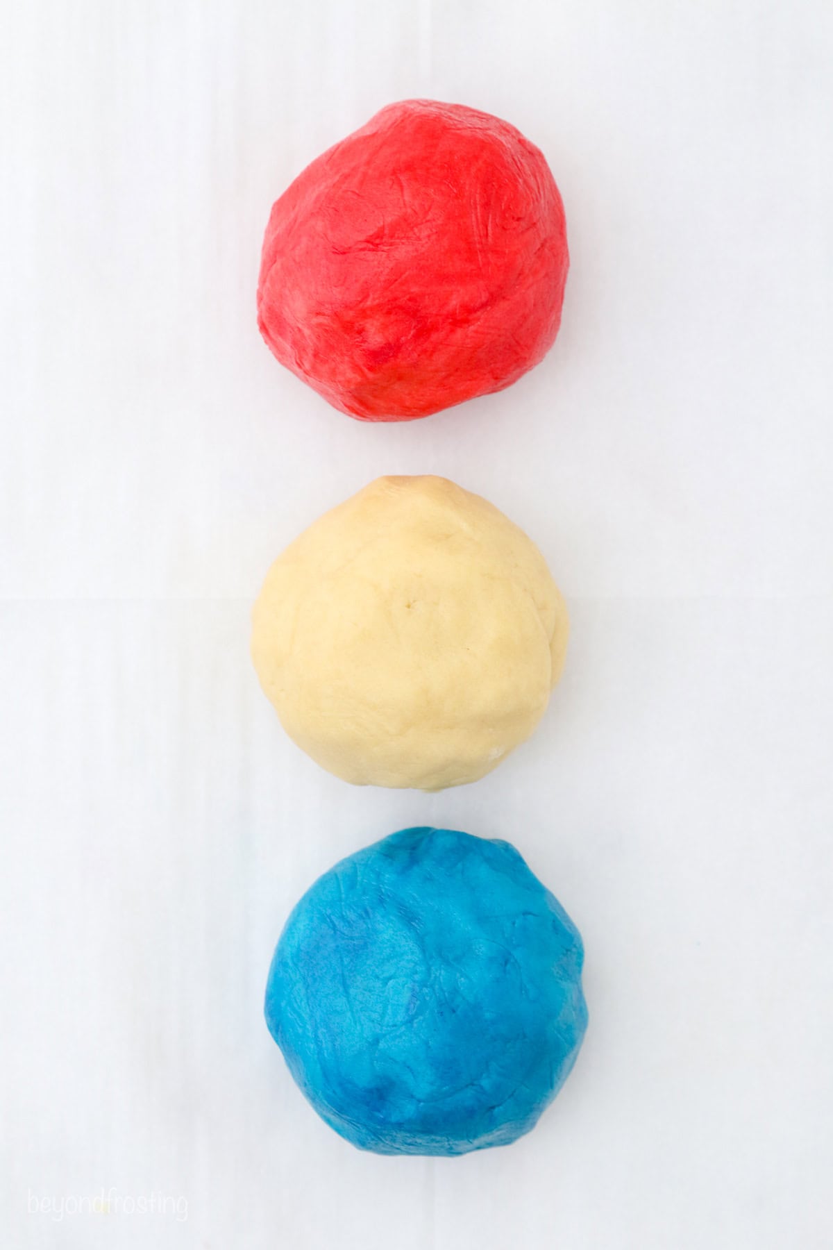 Three balls of cookie dough colored red, white, and blue.
