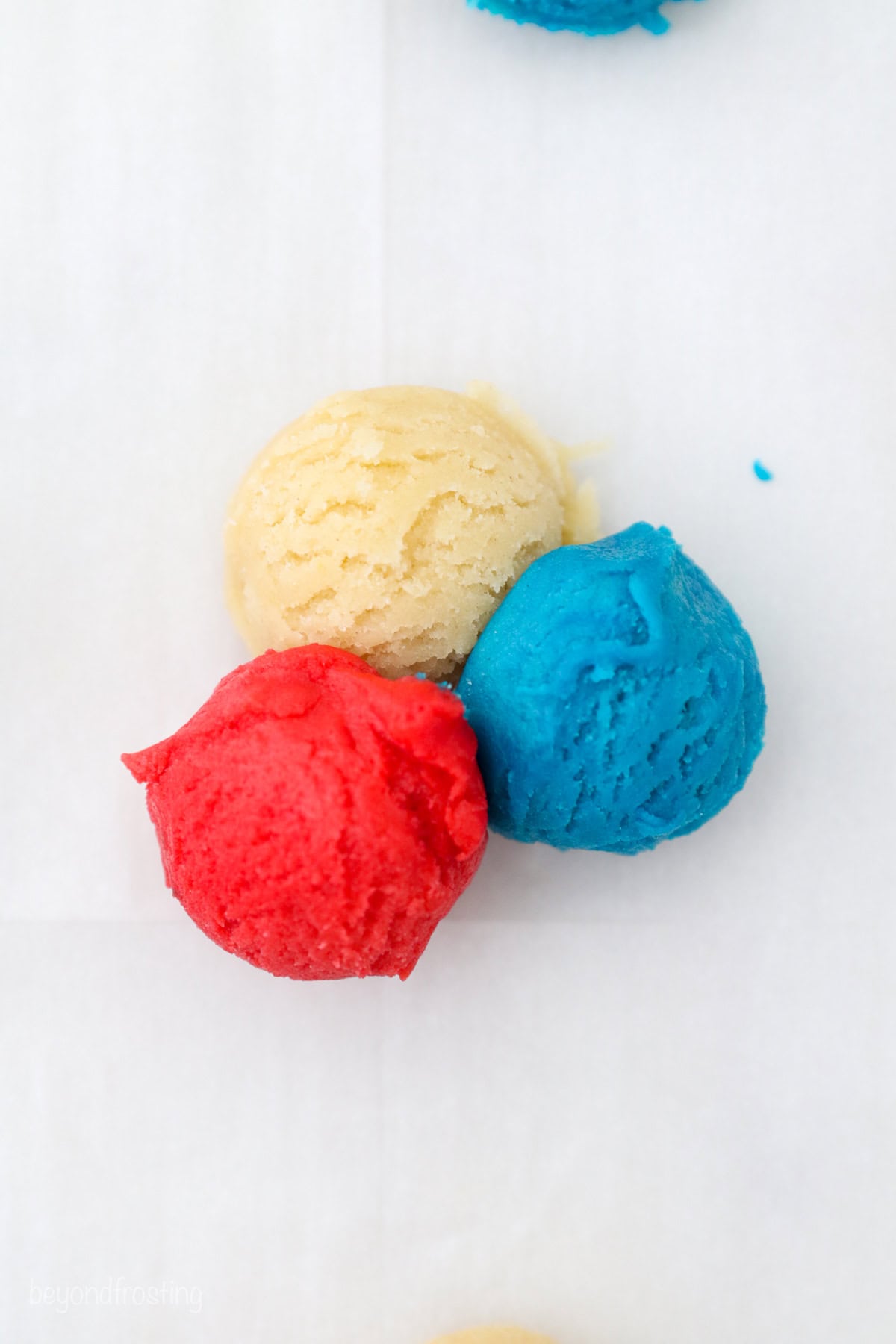 Three small scoops of red, white, and blue cookie dough arranged in a triangle.