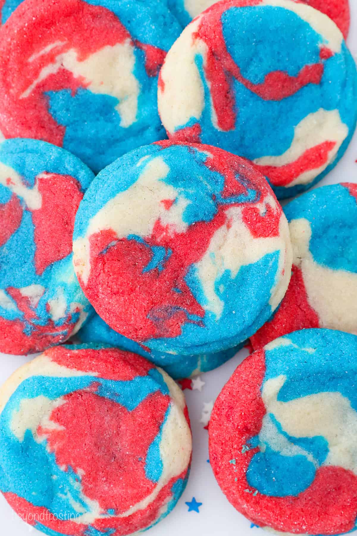 Overhead view of assorted red, white, and blue tye-dye patriotic sugar cookies.