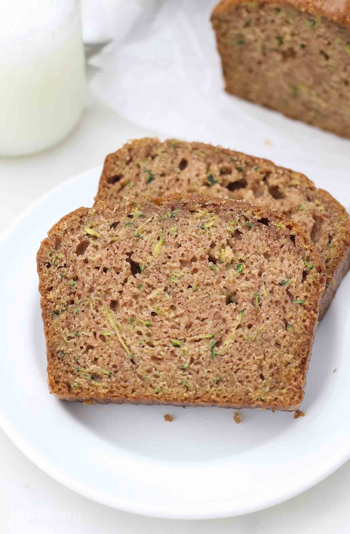 a white plate with two slices of zucchini bread