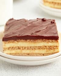 A slice of no-bake eclair cake on a plate, showing the creamy layers.