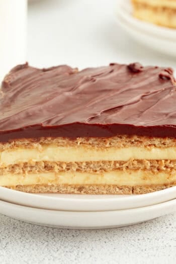 A slice of no-bake eclair cake on a plate, showing the creamy layers.
