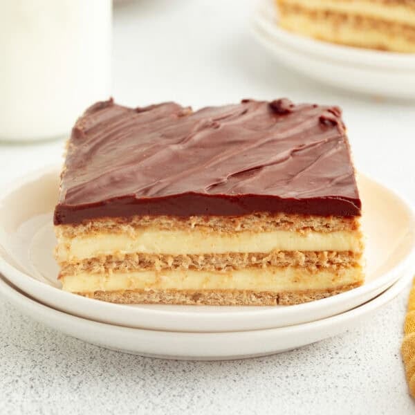 A slice of no-bake eclair cake on a plate, showing the creamy layers.