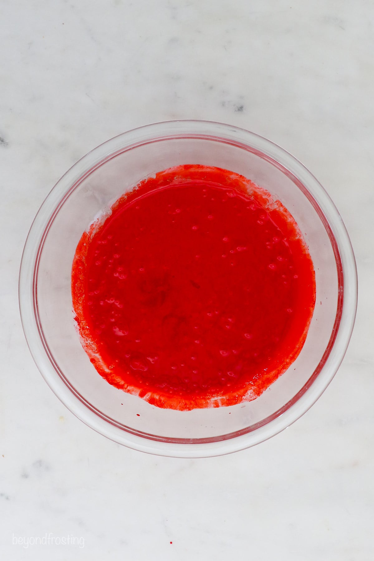 Red velvet cake batter in a glass bowl.