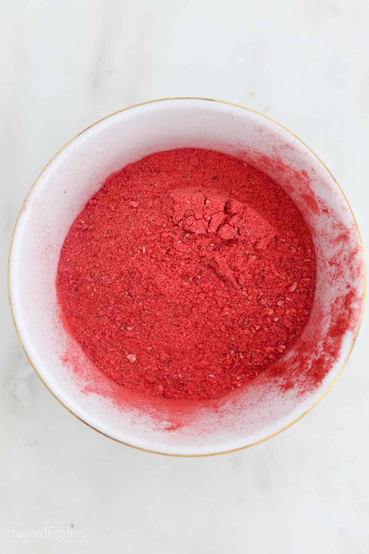 overhead of a white bowl with powdered freeze-dried strawberries