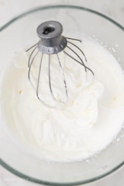 overheat shot of mixing bowl with a wire whisk with whipped cream