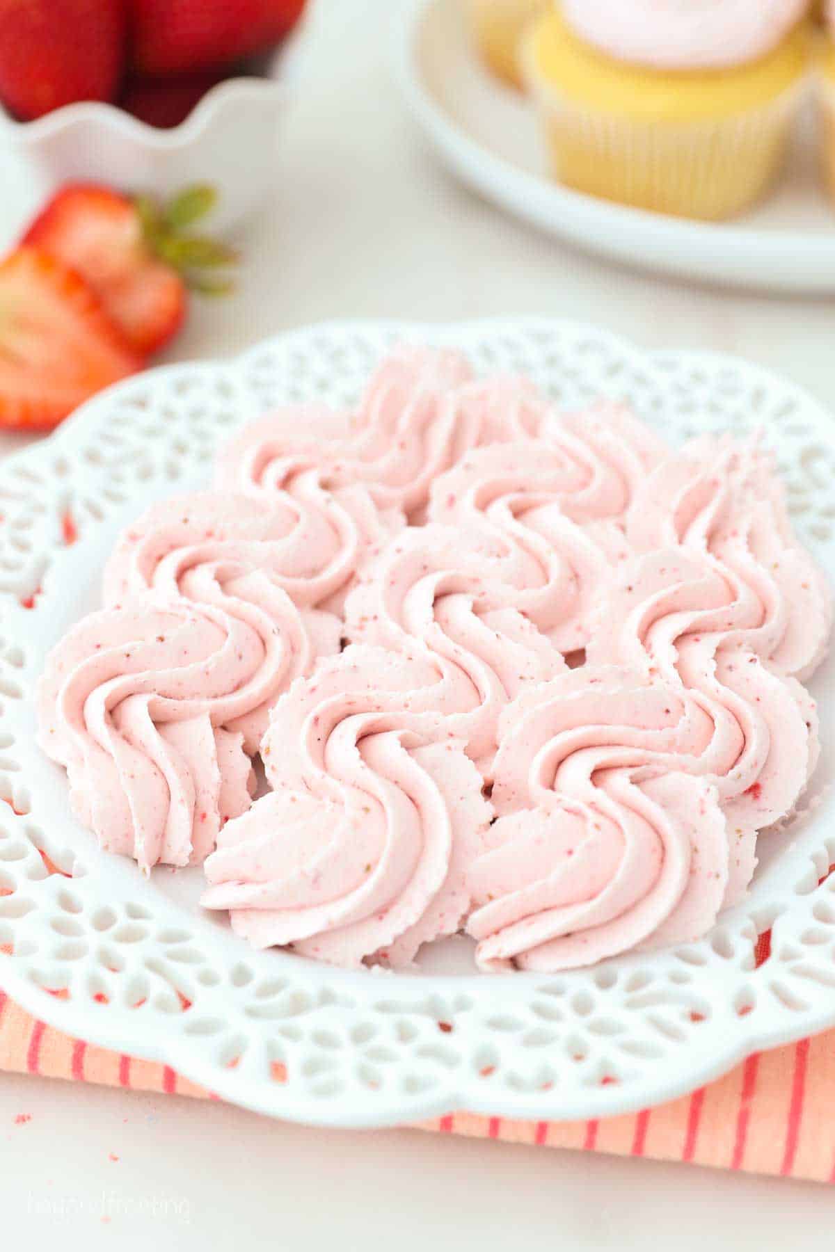 a white plate with pipped ribbons of strawberry whipped cream
