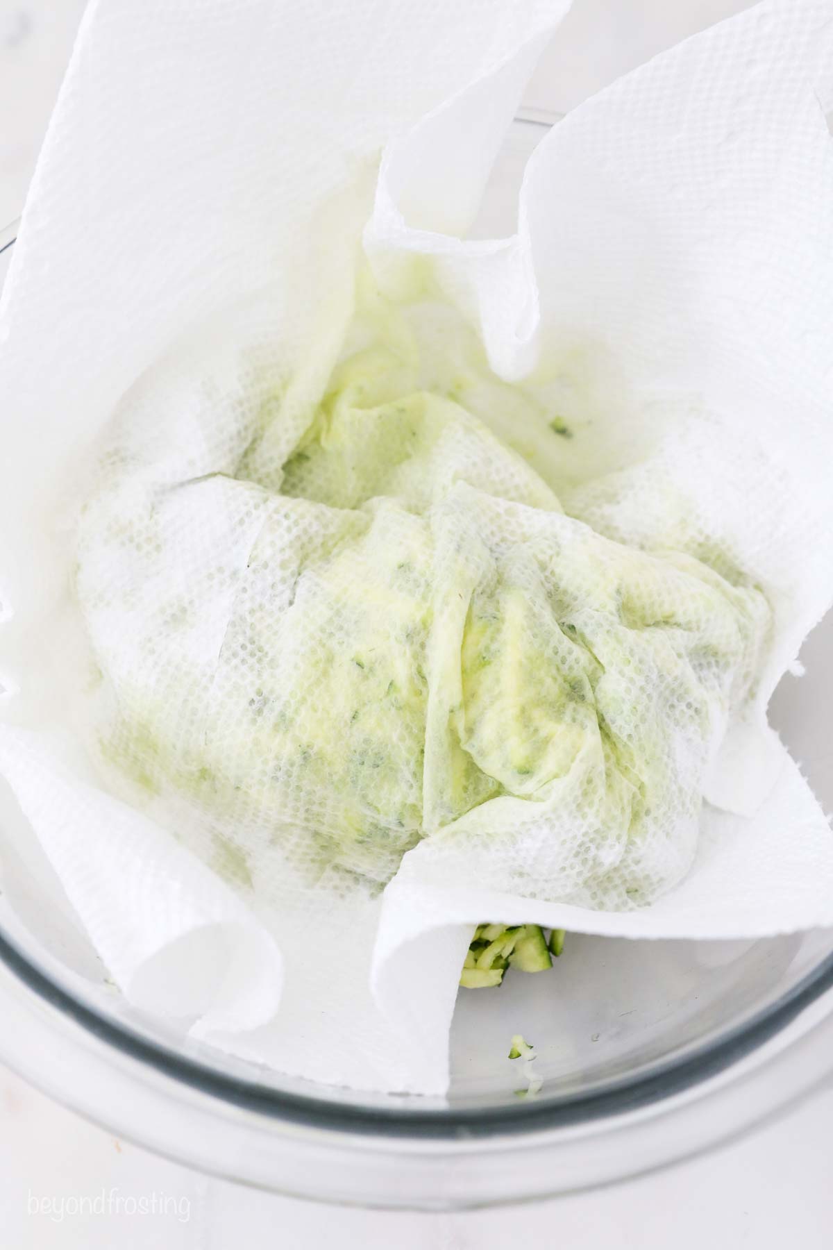 Make moist zucchini muffins loaded with melty chocolate chips! These freezer-friendly muffins are a delicious make-ahead breakfast or snack. Grated zucchini wrapped in a paper towel to remove moisture.