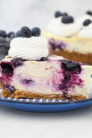 A close up of a slice of blueberry cheesecake on a blue polka dot plate