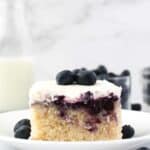 A slice of cake with blueberry filling on a white plate