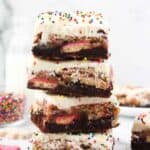 4 stacked brookie bars with frosting and sprinkles