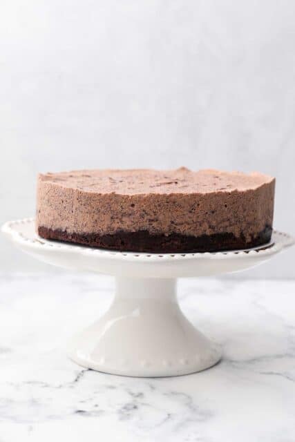 a white cake stand with a two layer chocolate cake