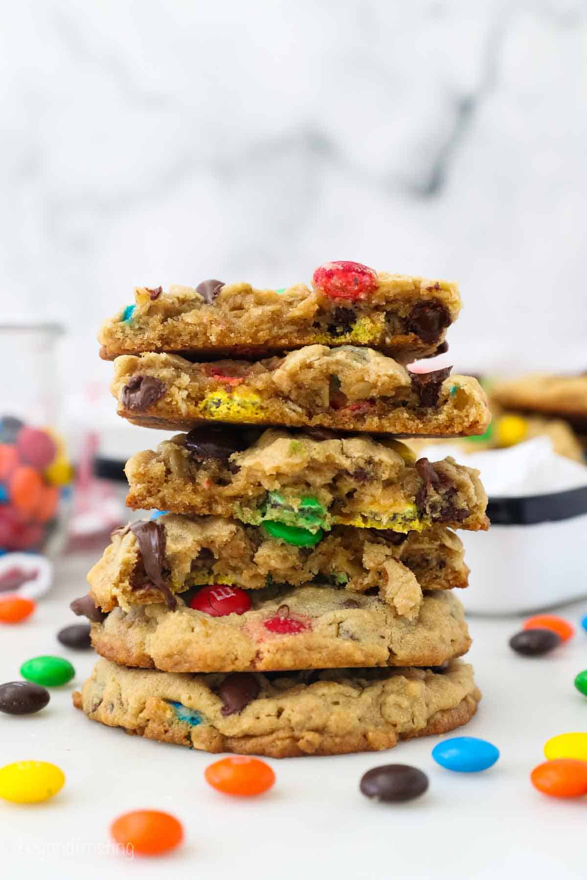 6 Monster Cookies stacked on top of each other with 4 of them being cut in half.