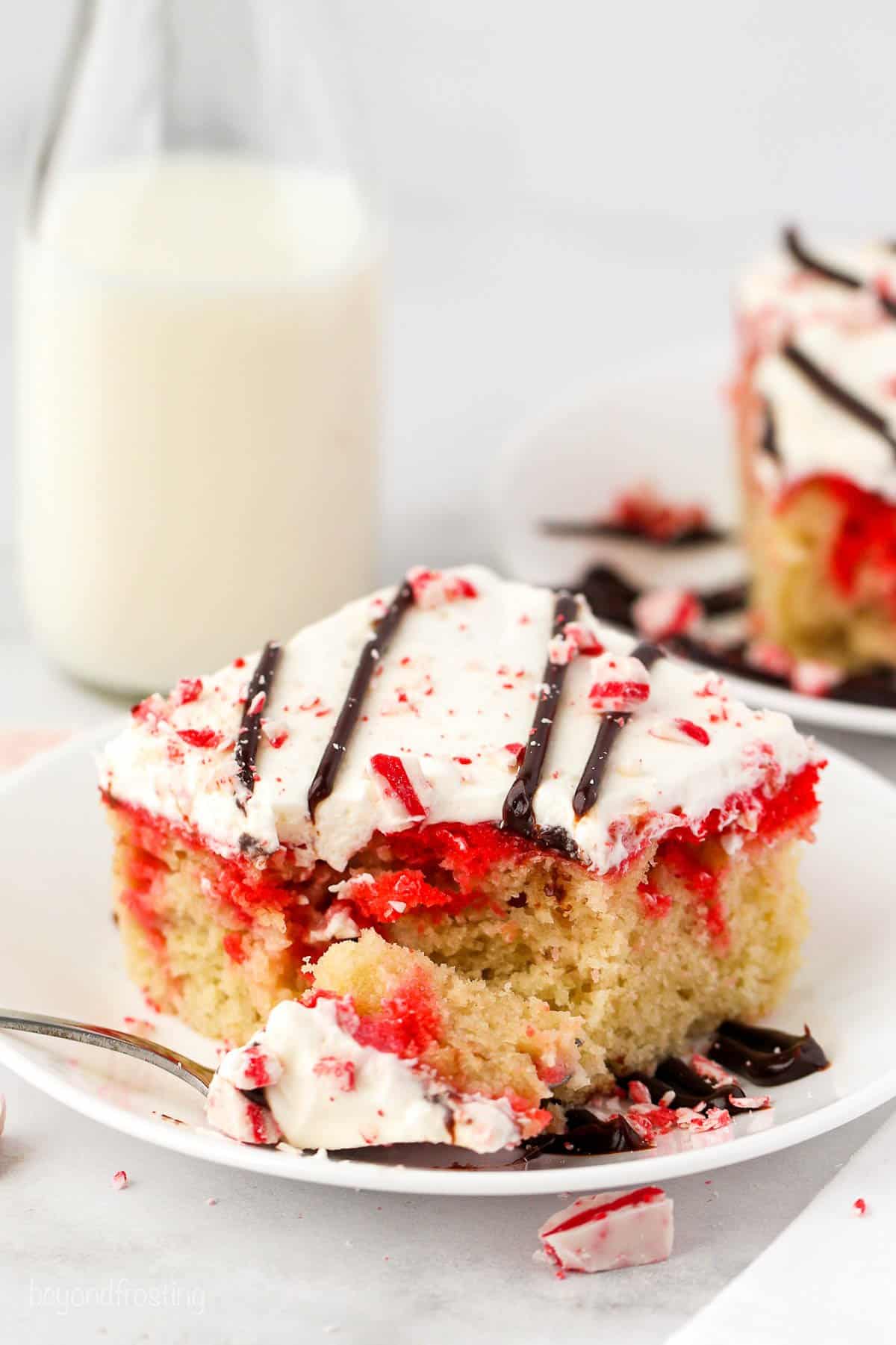 slice of peppermint poke cake with a bite on a fork