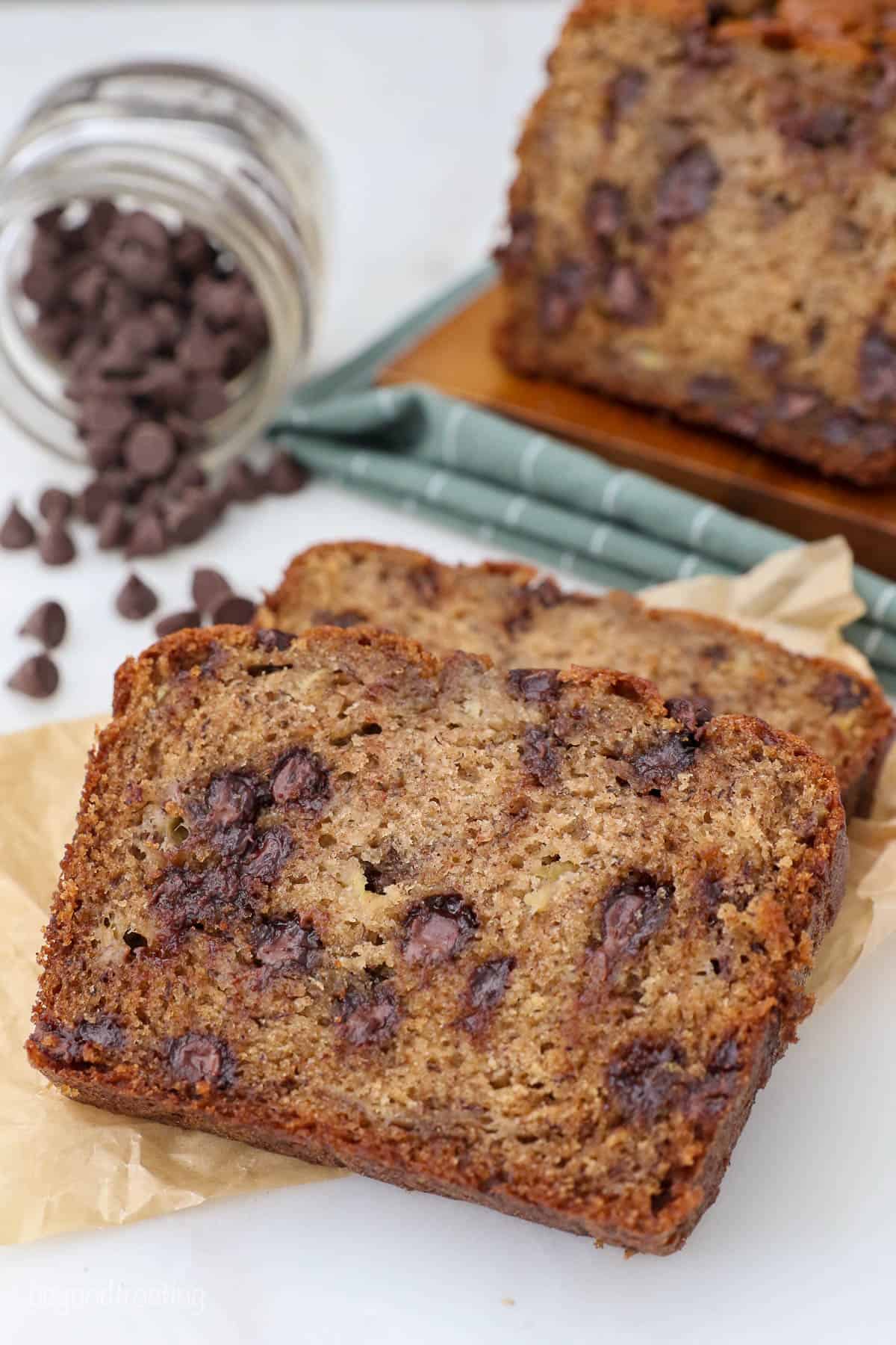 Slices of chocolate chip banana bread on a piece of brown parchment paper.