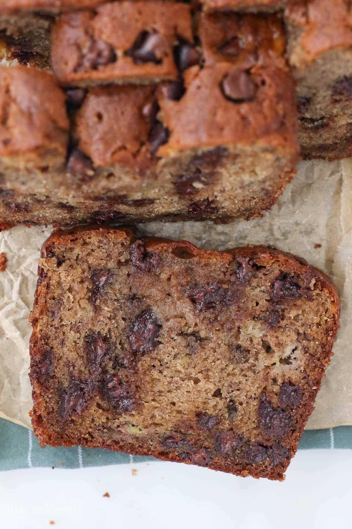 A slice of banana bread laying on brown parchment paper