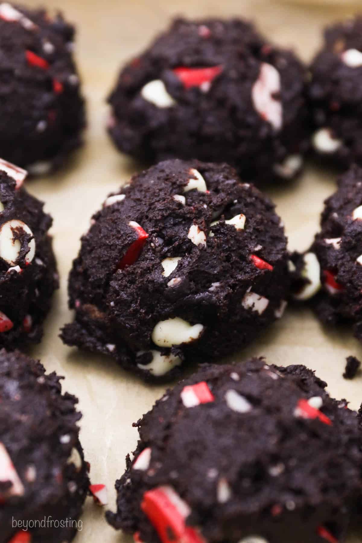 Close up of rows of double chocolate peppermint cookie dough balls on a baking sheet.