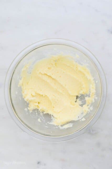 overhead view of a glass mixing bowl with creamed butter and sugar