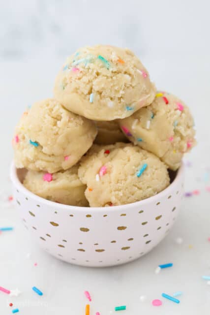 Scoops of sugar cookie dough in a pink bowl