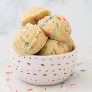 Scoops of edible sugar cookie dough in a pink bowl.