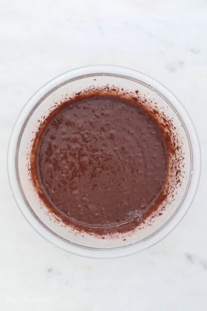 a glass mixing bowl with chocolate cake batter