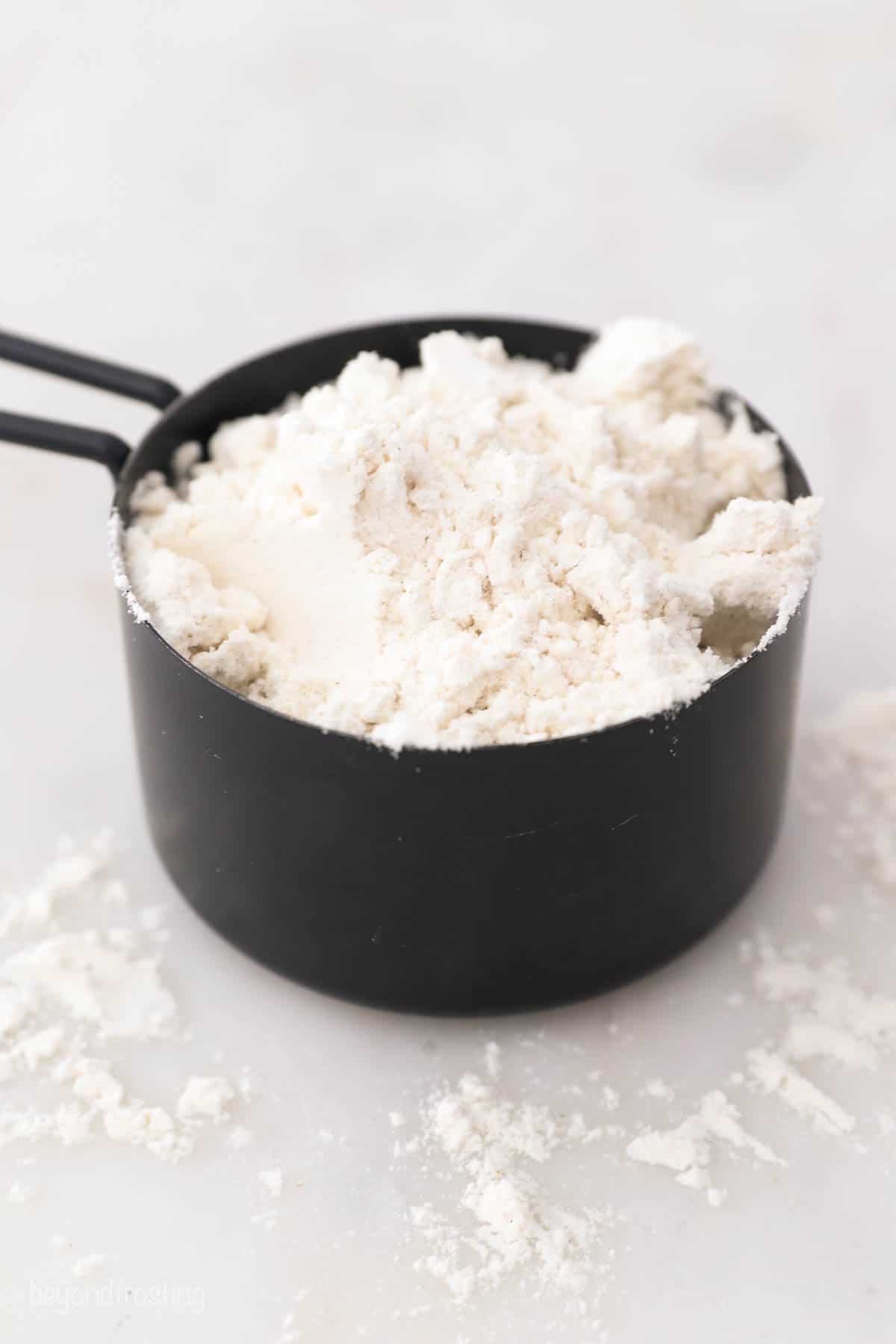 a black measuring cup with flour