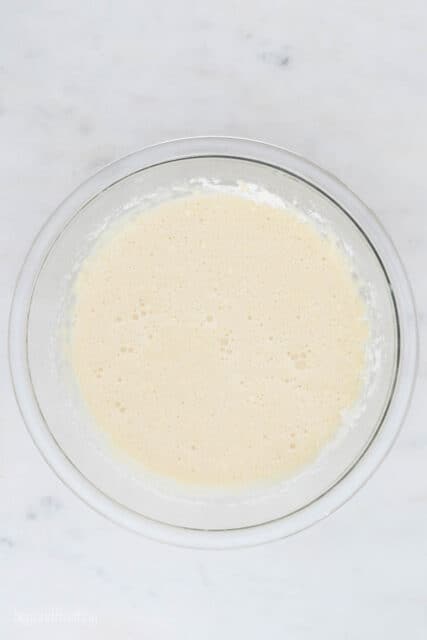 a glass mixing bowl with vanilla cake batter