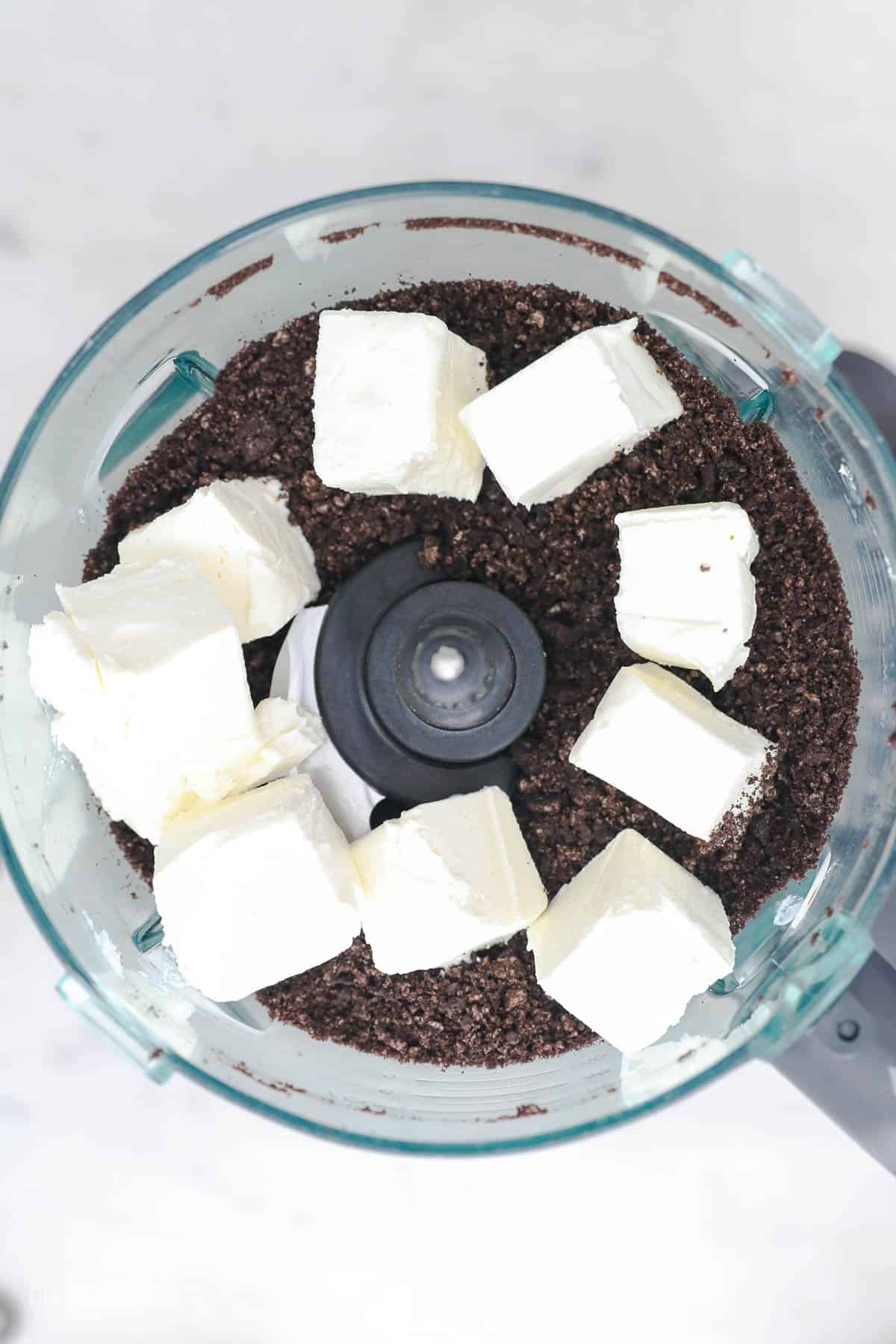 Oreo truffles come together fast, no baking required! With only 3 ingredients, these bite-sized Oreo balls make easy edible holiday gifts. Adding the cream cheese to the Oreo crumb.
